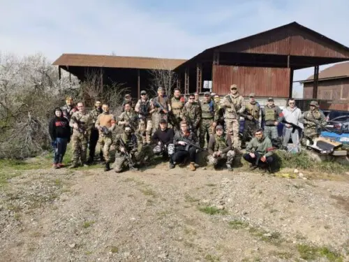 picture of an airsoft team posing on an outdoor field